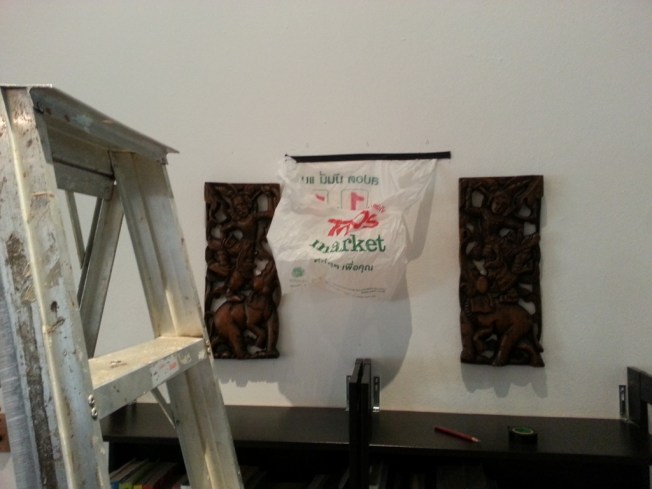 Innovation: plastic bag taped to wall, to catch falling dust from the holes about to be drilled in the concrete!